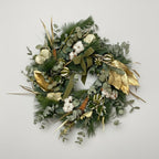 Corona de abeto natural navideño en color verdes y toques blancos y dorados. complemento de algodón y frutos deshidratados con aromas cítricos y canela.