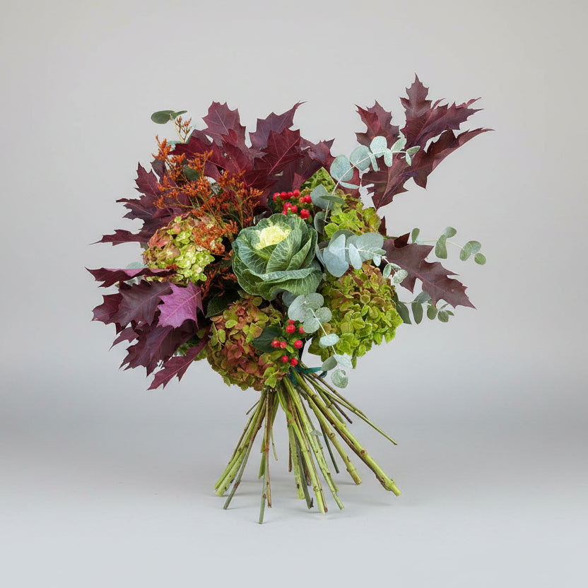 ramo en colores burdeos con hortensias naturales que secan super bien en colores verdes jaspeadas en tonos marrón y granate atado con una rafia en color verde.